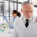 scientist holding vial medium shot scaled 1
