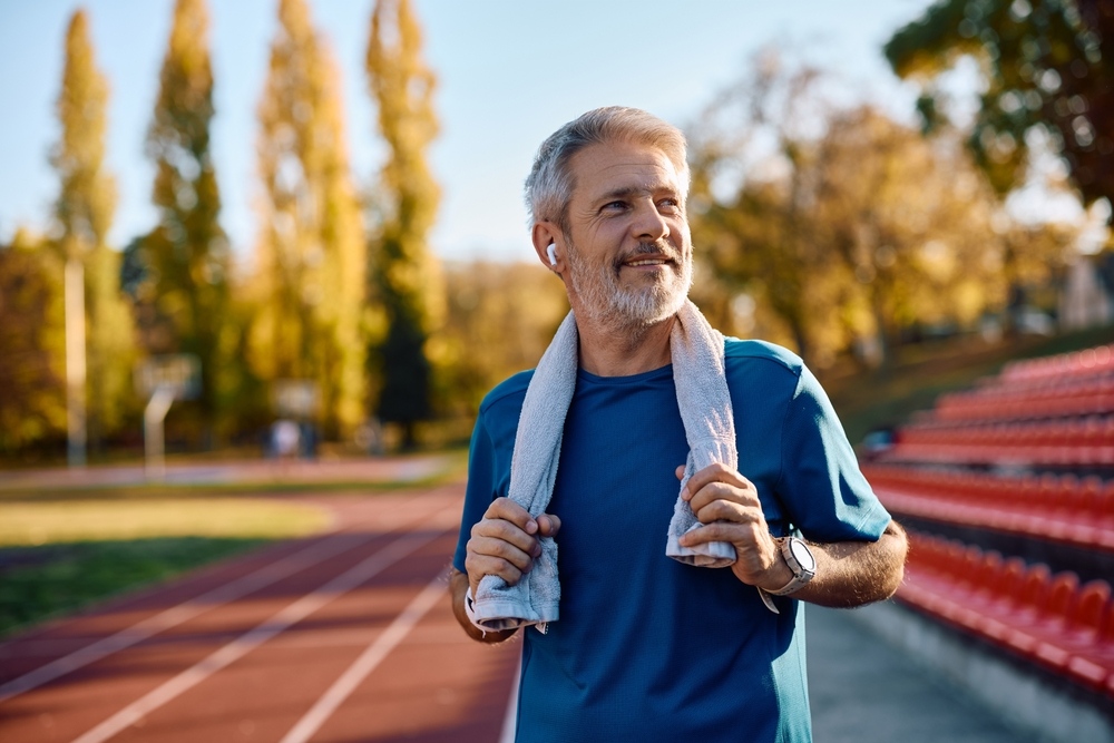 Active middle-aged man standing on a running track after exercise representing improved energy and vitality following TRT candidacy evaluation and testosterone therapy