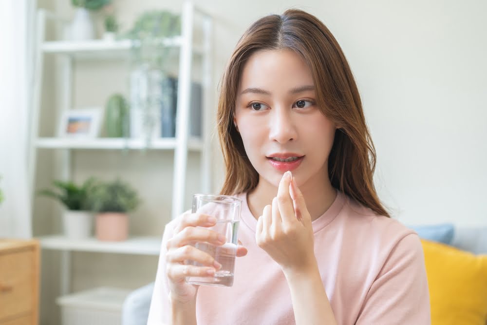 Woman taking a peptide supplement as part of a personalized program at a peptide therapy clinic serving Haddonfield NJ