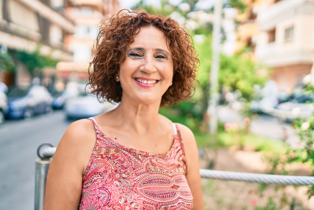 Middle-aged woman smiling outdoors with renewed energy and confidence from BHRT serving Moorestown NJ